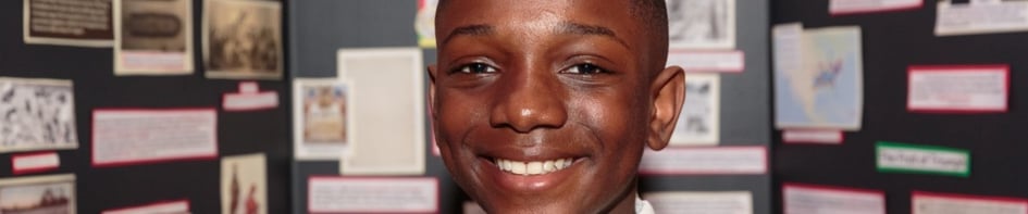 Student standing in front of poster board project.